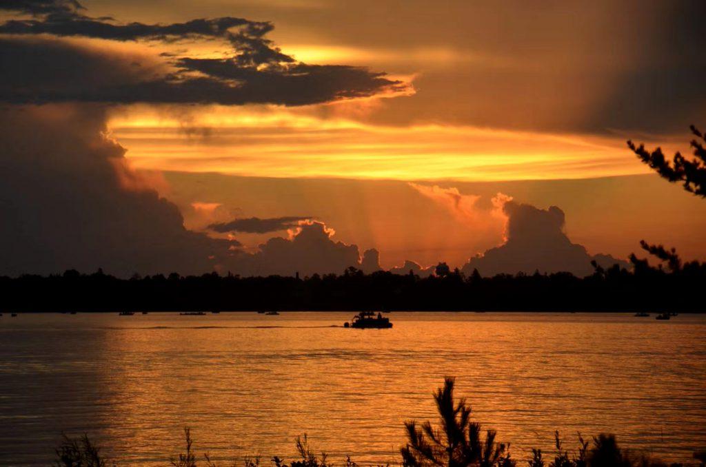 Lake Bemidji at sunrise with a pontoon on the lake